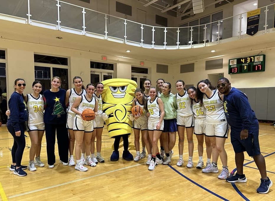The varsity basketball team poses with Sophie the Cyclone.