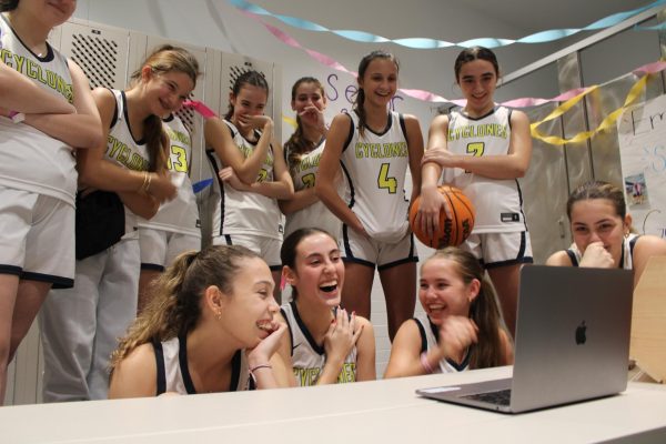 Members of the varsity basketball team watch the Senior Night video they made for Elizabeth Moss 24.