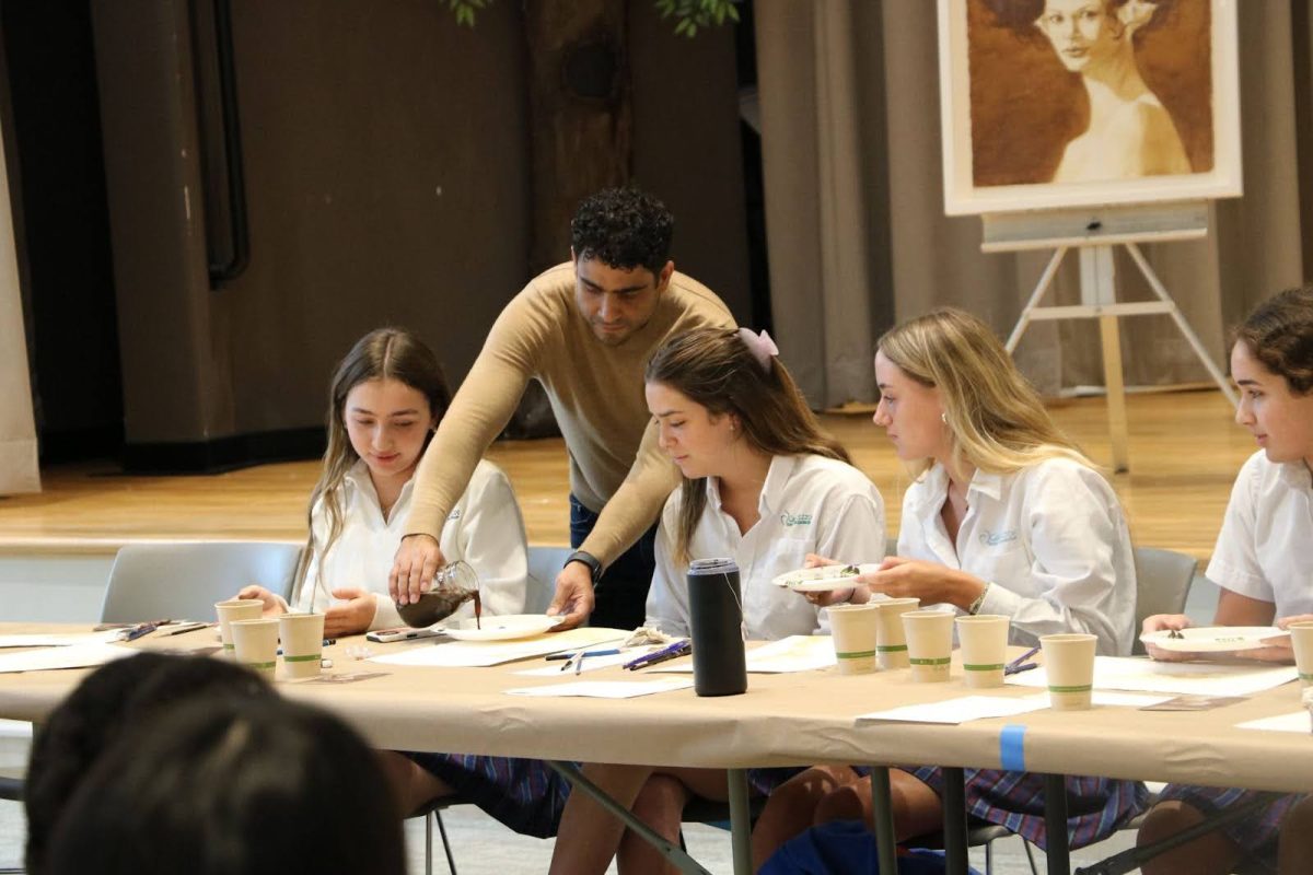 Llanes assists Lola Vazquez '25, Paulina Rodriguez '25, Nicki Sheer '24, and Mila Fanjul '25 during an art workshop
